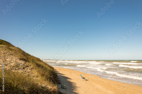 Solitary green chair on the sandy and windy beaches of the Adriatic sea