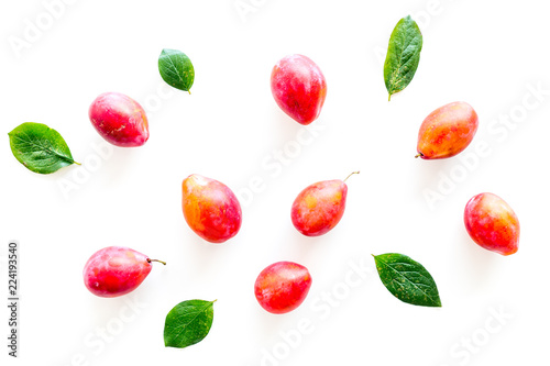 Fototapeta Naklejka Na Ścianę i Meble -  Summer harvest of red plum.  Red plum and leaves pattern on white background top view
