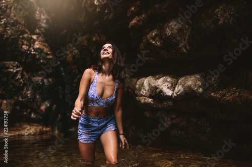 Beautiful tourust girl enjoying in the rainforest pond