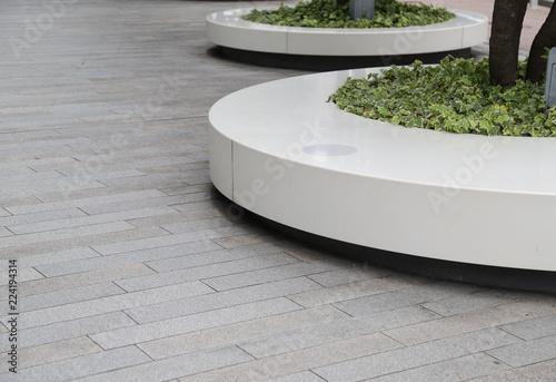 Closeup of designed outdoor circle bench with tree and cement floor.