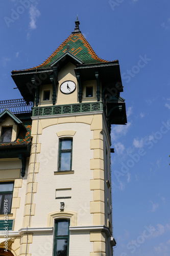 Fragment of a building with a tower with a round clock