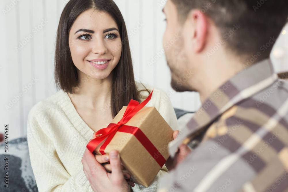 Handsome man surprising girl with Christmas gift Handsome man surprising girl with Christmas gift