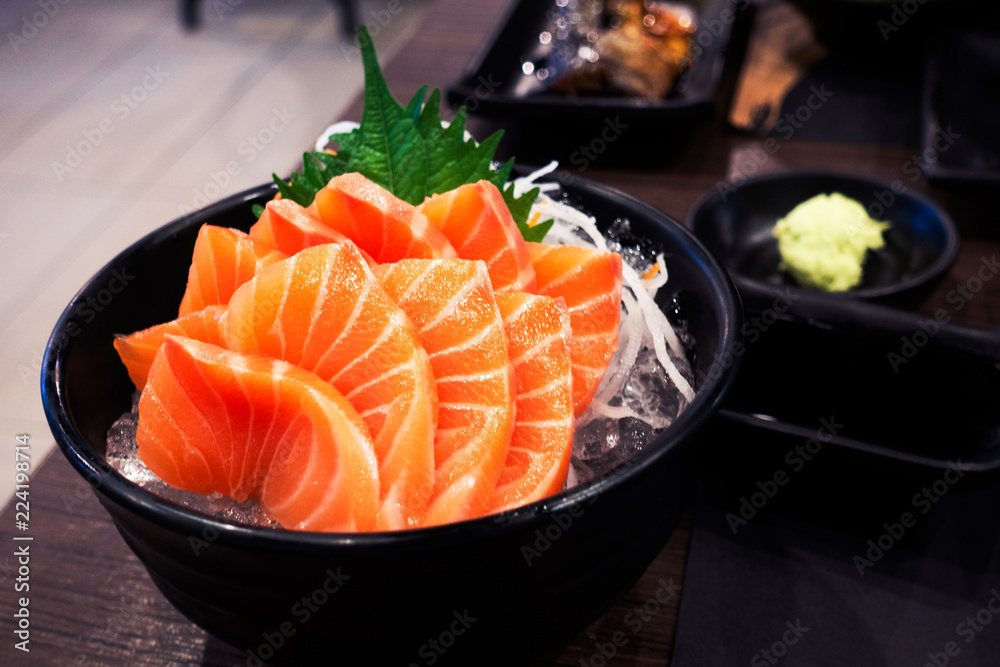 Sashimi salmon on the table in the restaurant light and dark. Sashimi salmon on the table in the restaurant light and dark.
