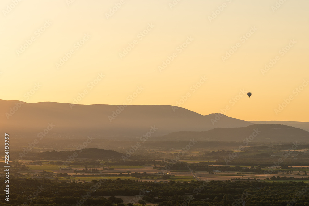 Hot-Air Balloon rising over French countryside at sunrise, Provence, France