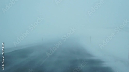 Extreme driving conditions trough strong blizzard Mountain road Very poor visibility View from inside car Iceland
