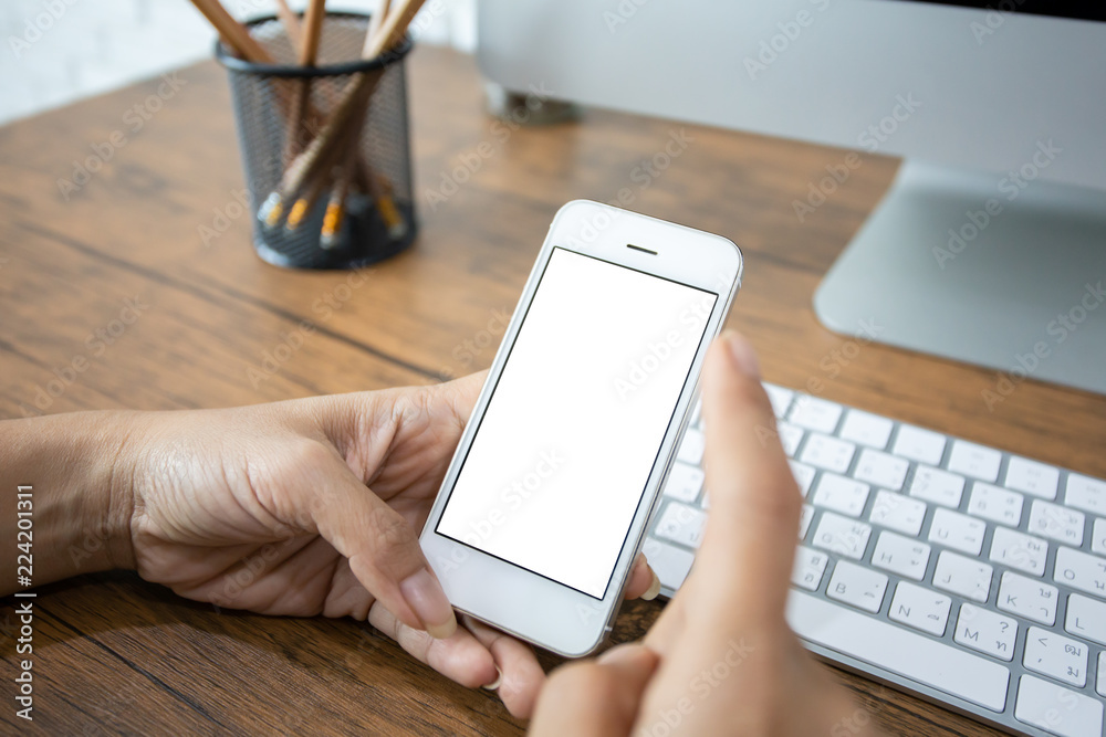 hand woman using a telephone, empty screen smart phone and computer on wooden table In home office. with clipping path hand woman using a telephone, empty screen smart phone and computer on wooden table In home office. with clipping path