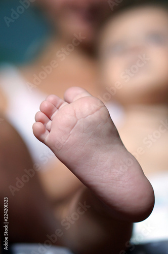 Feet of newborn baby with soft blur effect, motherhood theme conceptual photo
