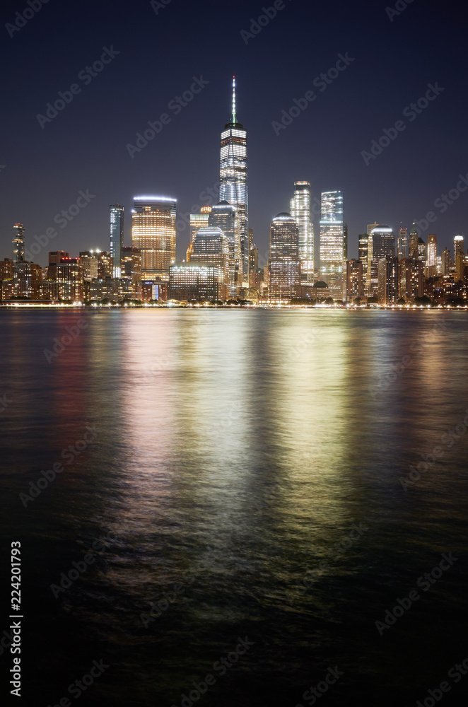 Manhattan skyline reflected in Hudson River at night, New York City, USA.