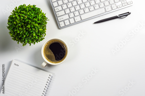 Office desk with coffee cup, blank notebook, black pen, laptop computer and plant pot, top view design