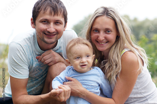 Parents with baby in park © Evgenia