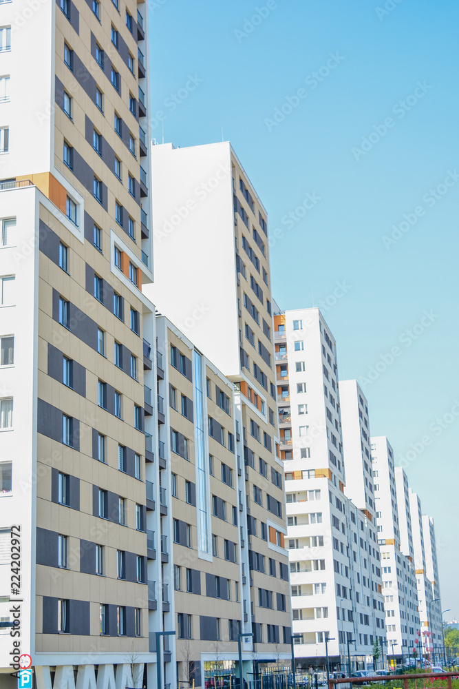 A multi-storey new residential building with balconies against the blue sky. New apartment house.