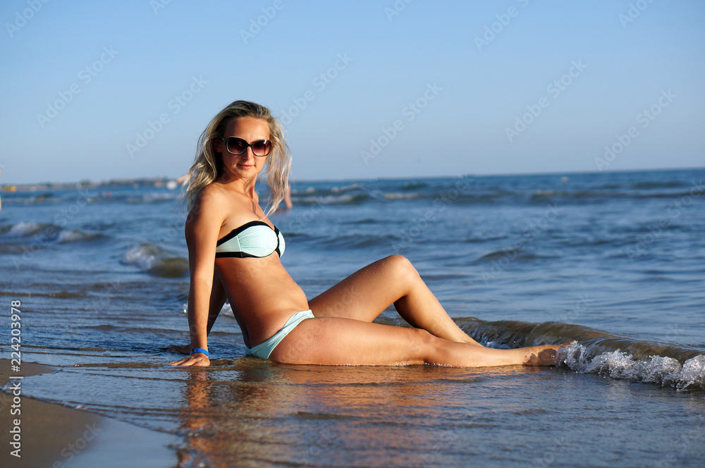 Portrait of the young beautiful woman on the beach in sun glasses Portrait of the young beautiful woman on the beach in sun glasses