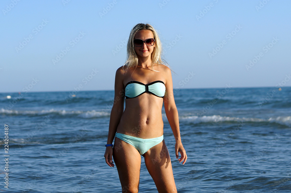 Portrait of the young beautiful woman on the beach in sun glasses