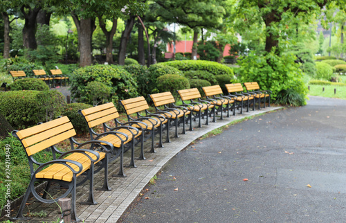 Closeup of yellow outdoor chairs in public park after raining.