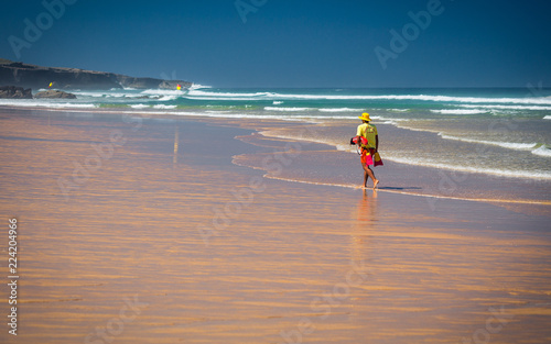 Lifeguard walking along beach on wild coast of Alentejo, Portugal