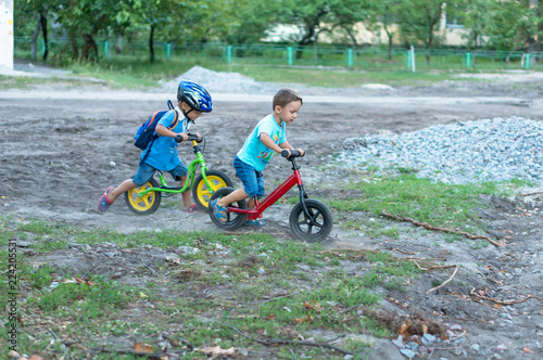 Funny two active little boys riding on bicycle on warm summer day. Countryside. Active leisure and © Evgenia