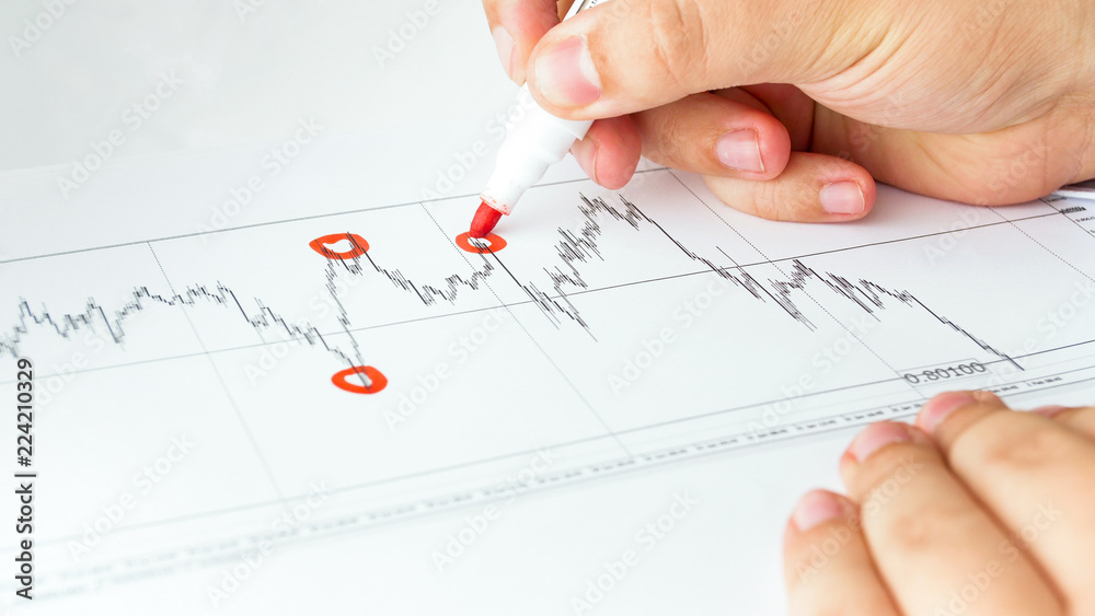 Closeup image of business consultant analyzing financial graph and marking points of growth and crisis Closeup image of business consultant analyzing financial graph and marking points of growth and crisis