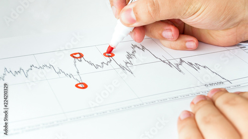 Closeup image of business consultant analyzing financial graph and marking points of growth and crisis