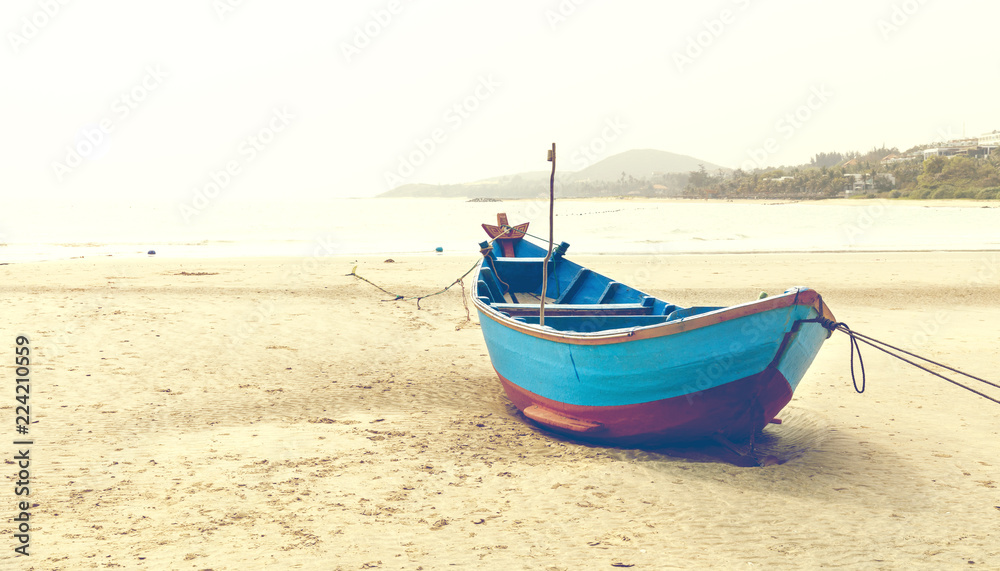 Blue fishing boat on sandy beach in Vietnam