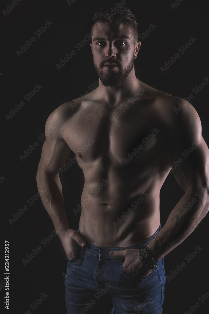 Athletic Strong Sexual Man Abs Six Pack Muscles Bodybuilding And Fitness Concept. Studio shot, Low key, copy space on black background