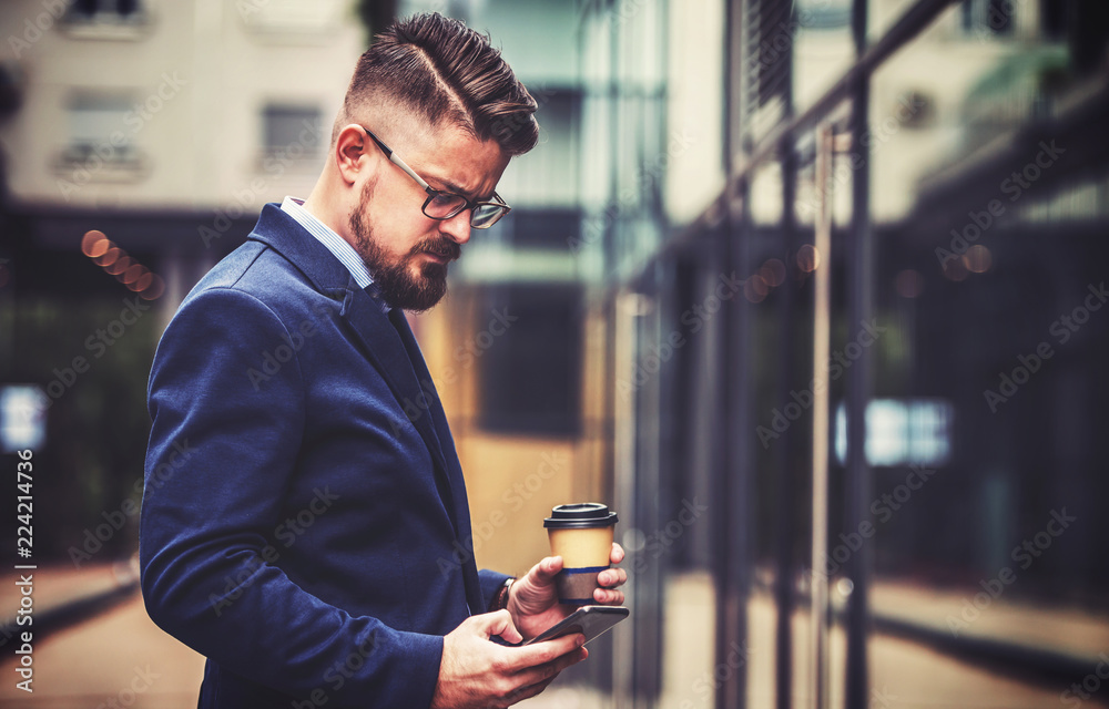 Young business man drinking coffee and using digital tablet outdoor. Business, education, lifestyle concept Young business man drinking coffee and using digital tablet outdoor. Business, education, lifestyle concept