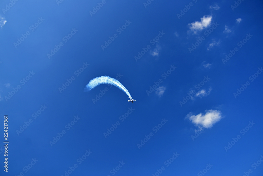 Airplane in the blue sky performing aerobatics at airshow Airplane in the blue sky performing aerobatics at airshow