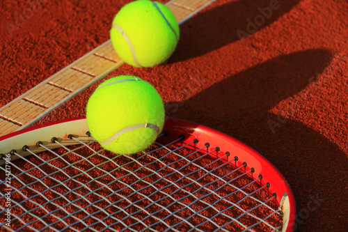Tennis ball and racquet on a tennis clay court © Željko Radojko