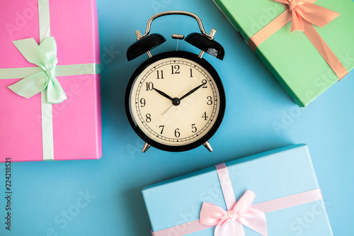 Festive holiday New Year and Christmas blue background with gift boxes, alarm clock. Concept of carnival, birthday, party. Flat lay. Top view.