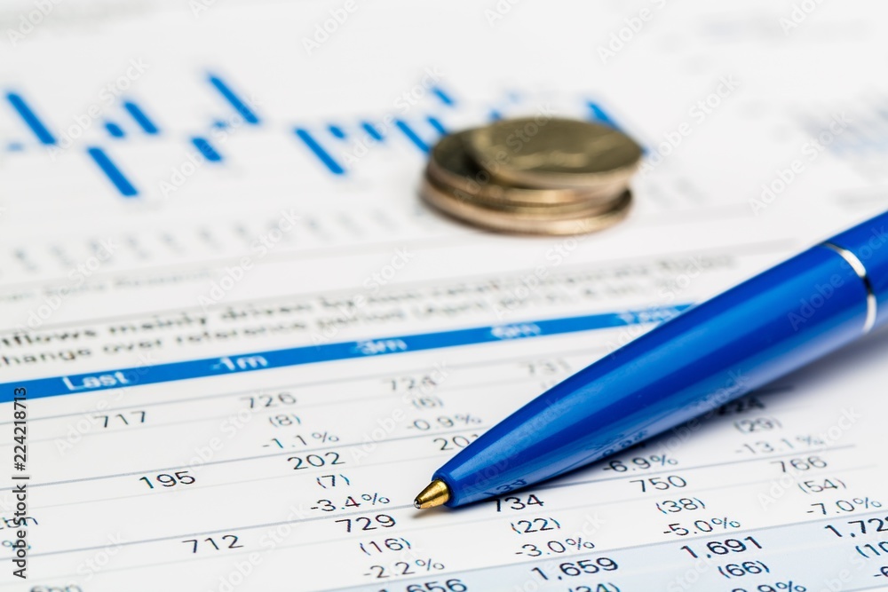 Pen and Coins on Business Graphs and Charts Pen and Coins on Business Graphs and Charts