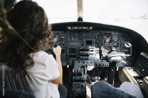 Brunette woman navigating plane photo