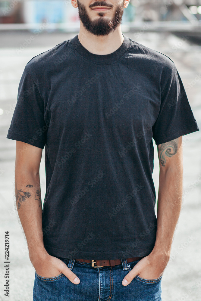 A stylish man with a beard with a black T-shirt. Street photo A stylish man with a beard with a black T-shirt. Street photo