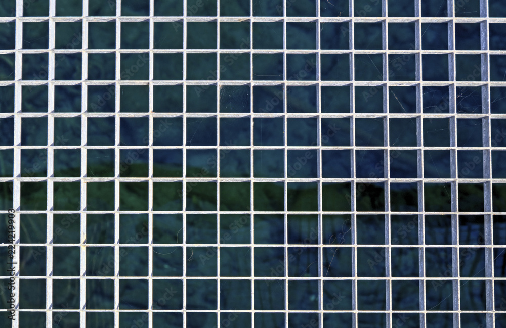 Metal grid above the water surface closeup