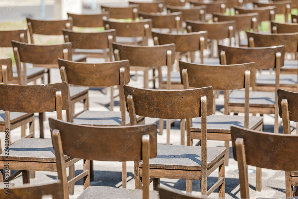 Commemoration memorial to the holocaust of Jews: art installation of empty chairs at city street Commemoration memorial to the holocaust of Jews: art installation of empty chairs at city street