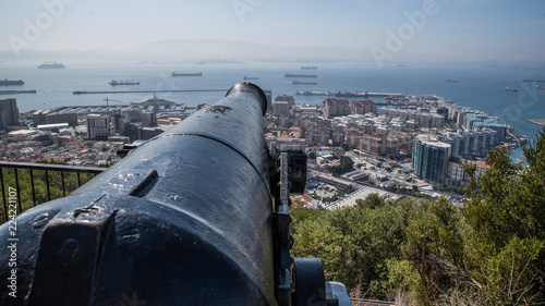View from the Rock of Gibraltar towards the bay. A leading line provided by an old gun. Sea with merchant ships as backdrop, the city of Gibraltar takes the center of the picture.