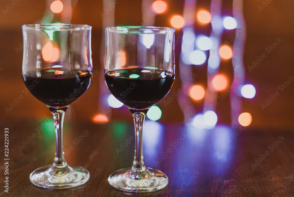 two glasses of red wine on the background of lights