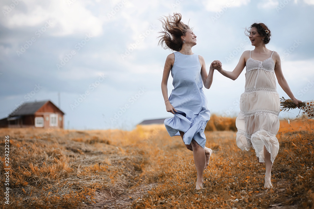 Two girls in dresses in autumn field Two girls in dresses in autumn field