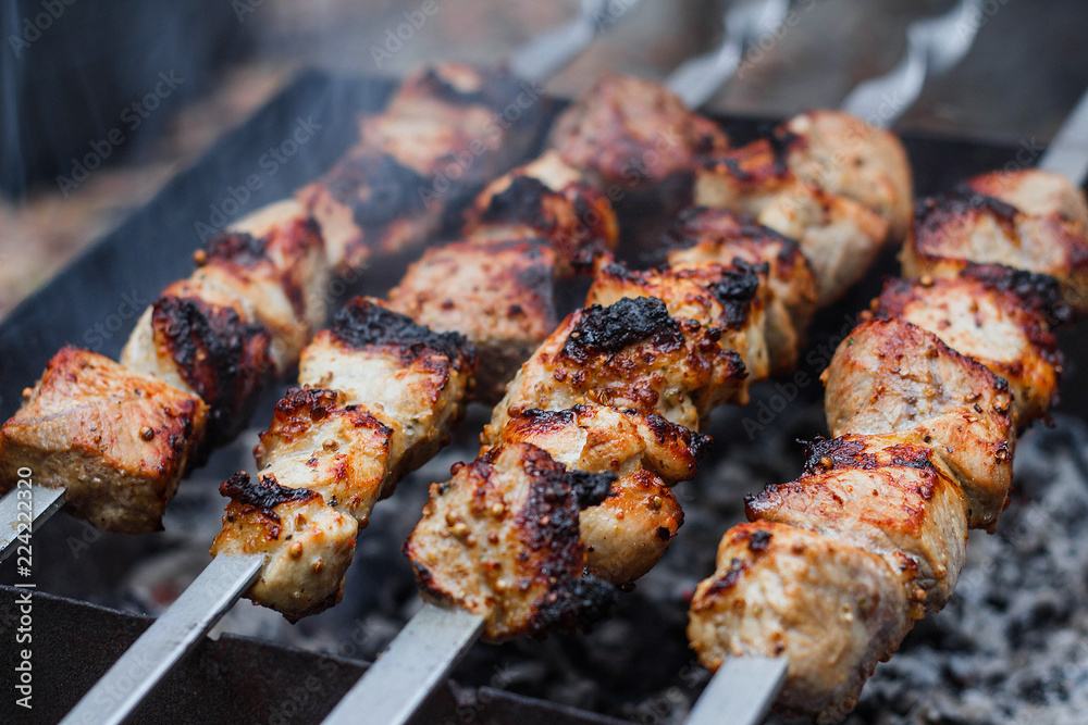 Barbecue on the grill. Shashlik made of cubes of meat on the skewers during of cooking on the mangal over charcoal Barbecue on the grill. Shashlik made of cubes of meat on the skewers during of cooking on the mangal over charcoal