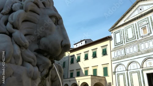 View of Collegiata Sant’Andrea church, Empoli, Italy. Sight of main square of the city, Piazza Farinata degli Uberti, Tuscany, with lions fountain and Florentine Romanesque facade of basilica
