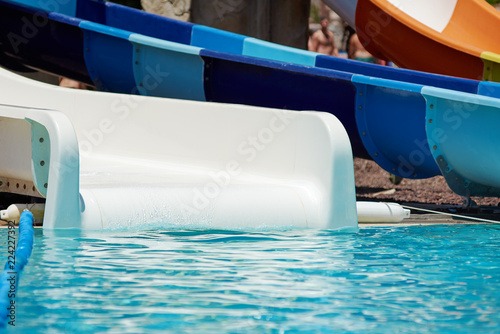 White plastic water slides in waterpark pool.