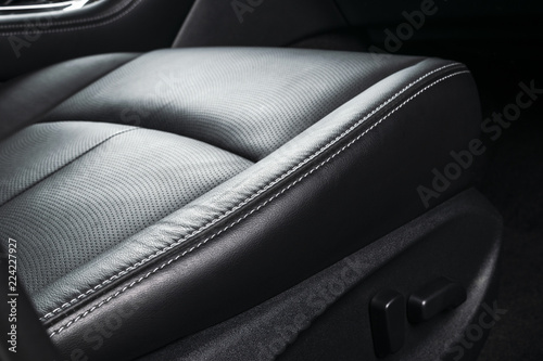 Modern Luxury car inside. Interior of prestige modern car. Comfortable leather seats. Perforated leather with stitching isolated on black background. Modern car interior. Car detailing.