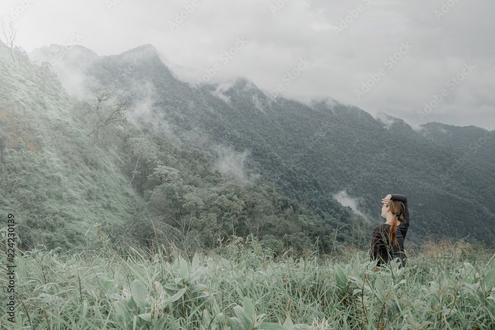 Cute girl hiking adventure on the high mountain with beautiful views of mist. Vintage style at Doi Phu Kha in Nan.