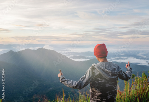 Handsome young man hiking on sunny days in the forest, the green hills. at Doi Phu Kha in Nan.