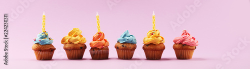 Tasty cupcakes on pinke background. Birthday cupcake in rainbow colors.