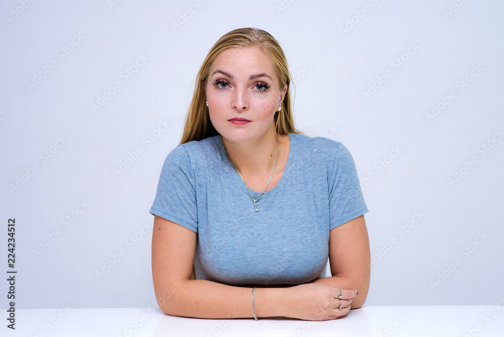 Fototapeta premium Studio portrait of a beautiful blonde girl on a white background in different poses with different emotions