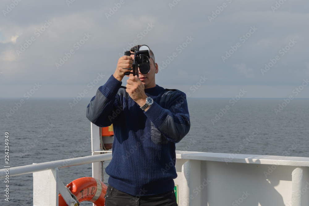 Obraz premium Seaman with sextant on navigational bridge