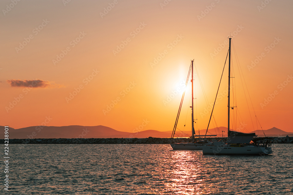 Silhouettes of yachts against the setting sun
