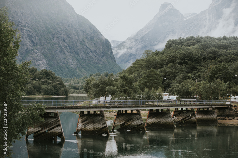 A foot bridge crossing a large river in the Norwegian mountains.