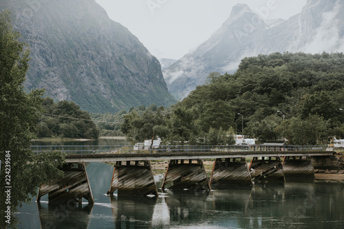 A foot bridge crossing a large river in the Norwegian mountains.