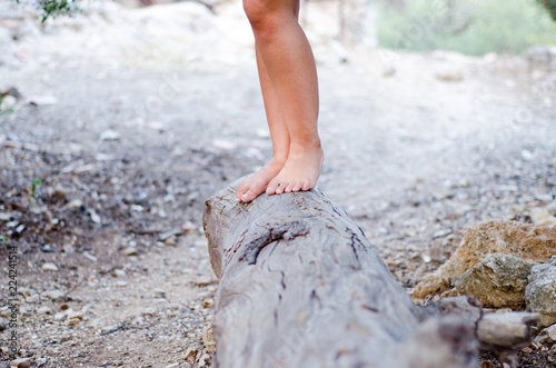 girl wearing a dress  walking barefoot on a large stump