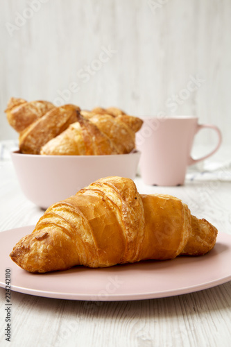 Fresh croissants with cup of coffee, side view. Selective focus.